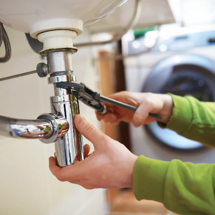 Hardware & Plumbing SuppliesA wrench being used to fix a pipe underneath a sink